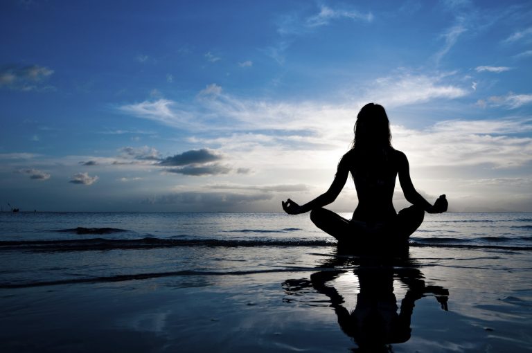 Person meditating by the sea